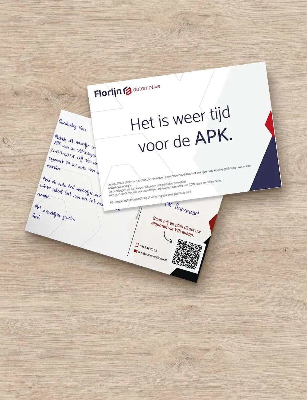Geschreven APK-herinnering van een autobedrijf met een QR-code om een afspraak te maken, op een houten tafel