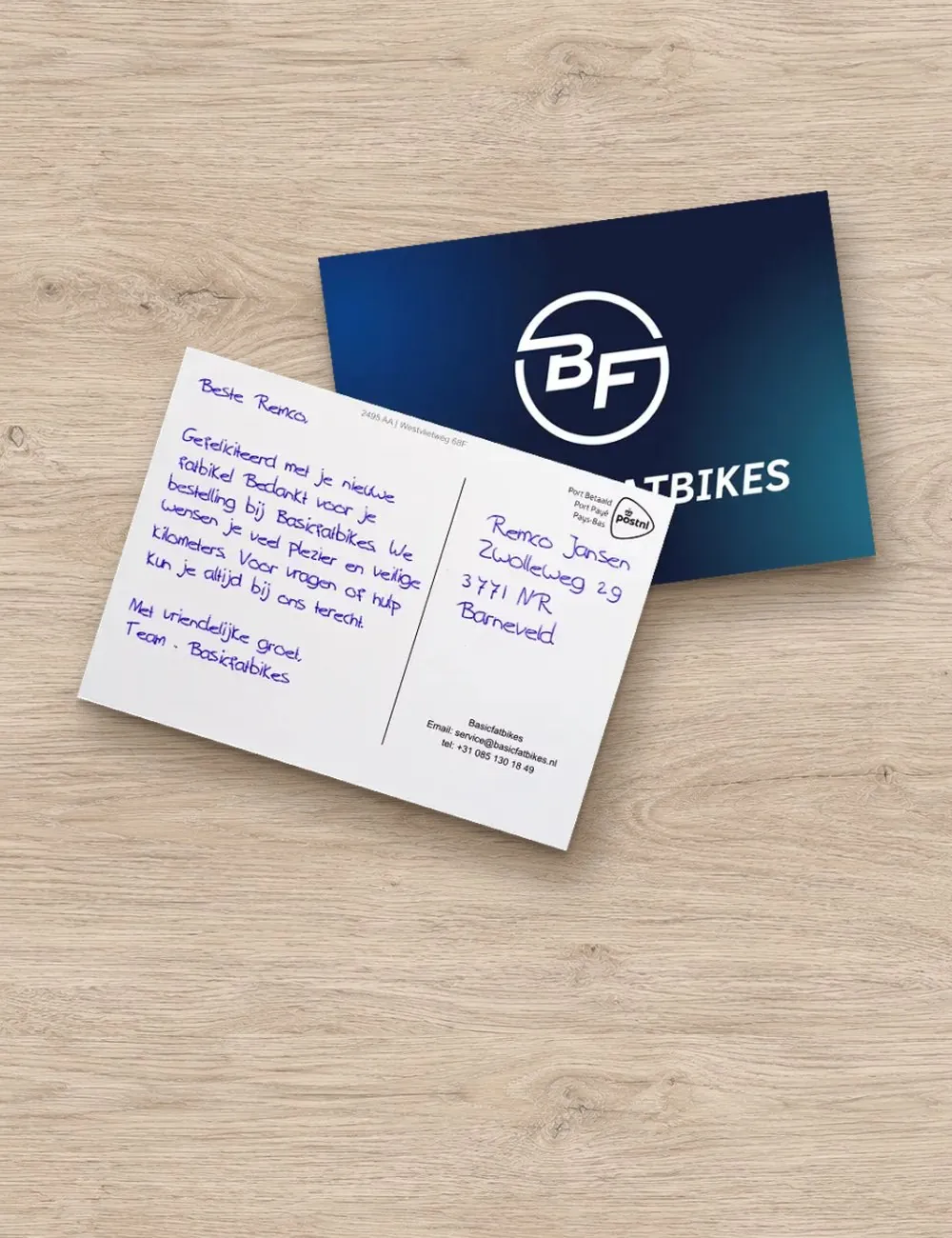 Bedankkaart van een fietsenwebshop na een bestelling, op een houten tafel