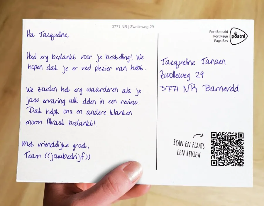 Hand houdt een reviewkaart met QR-code vast