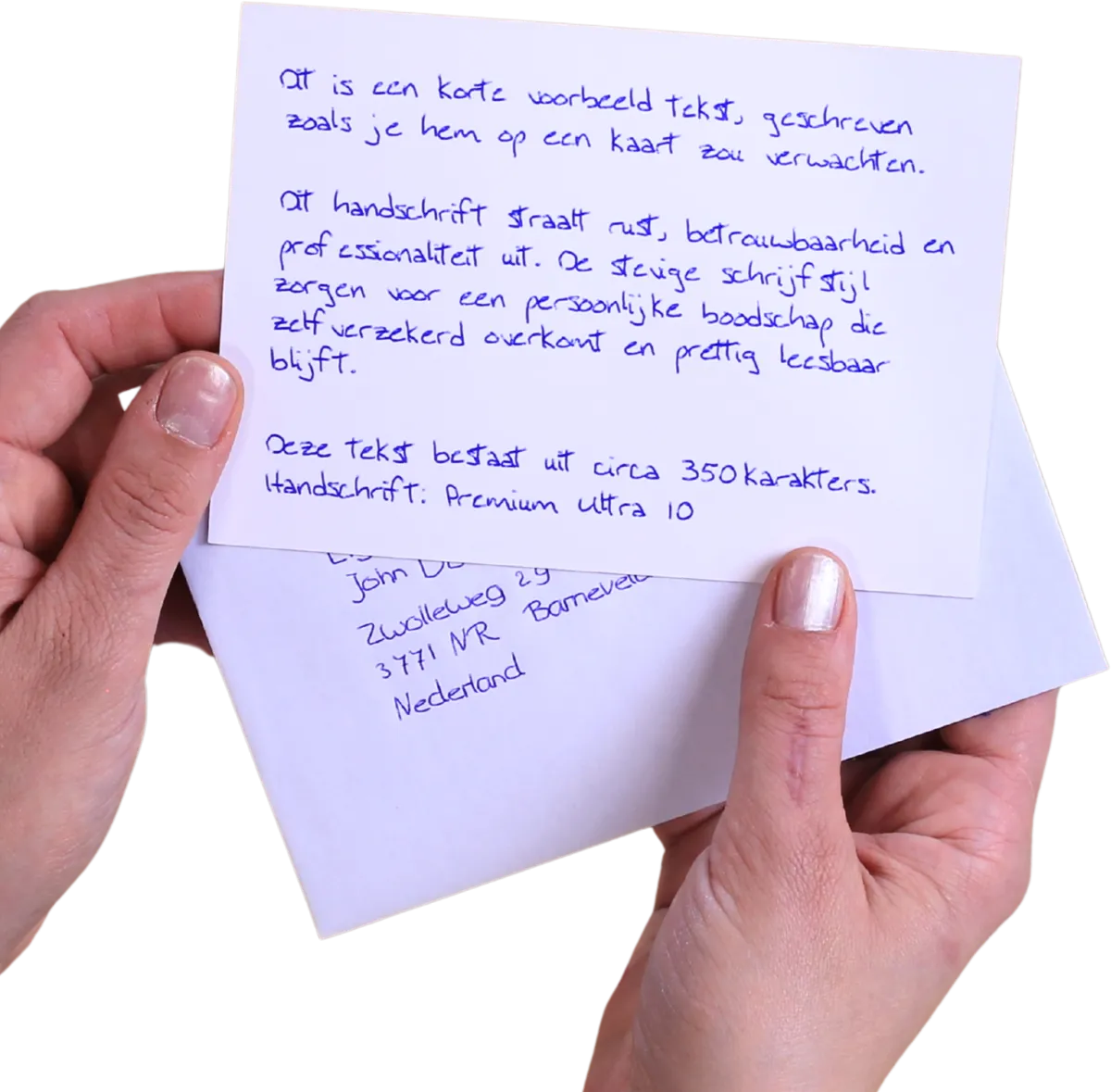 Two hands holding a handwritten card above an envelope with an address written by pen